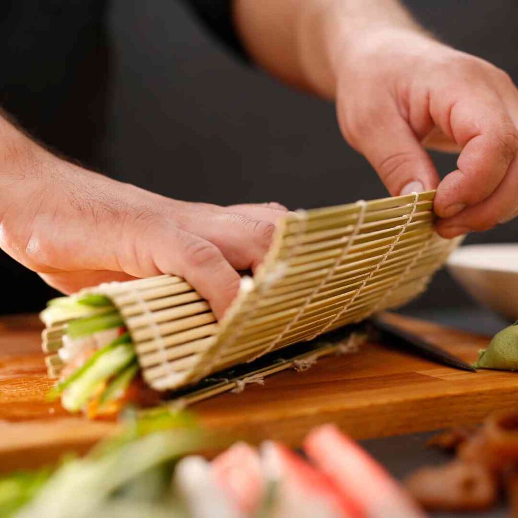 เชฟที่ปรึกษากำลังสอนเทคนิคการทำอาหารให้พนักงานครัวอย่างใกล้ชิด